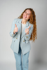 Young Woman Giving Ok Sign on gray background
