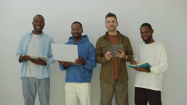 Group portrait of team of multi-ethnic developers posing for camera isolated on white background indoors