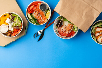 Different poke bowls on blue background top view