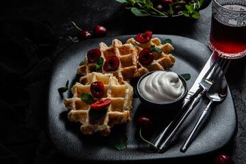 Viennese waffles with cherries on a dark background. Belgian waffles