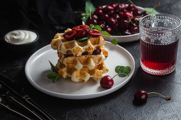 Viennese waffles with cherries on a dark background. Belgian waffles