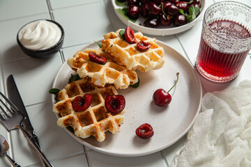 Viennese waffles with cherries on a dark background. Belgian waffles