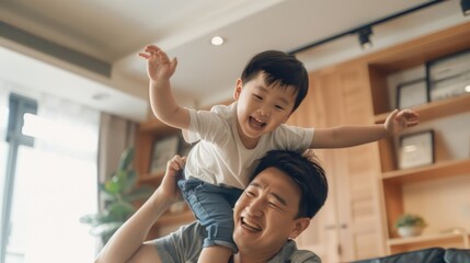 A father or male guardian lifting a young child into the air, possibly for a photo opportunity or to show affection