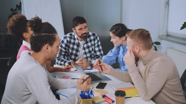 Team members engage in heated discussion to develop a consensus during an office meeting. Expressions and gestures show intensity and focus. Concept of collaboration and decision-making