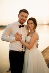 bride and groom against the backdrop of a yellow sunset