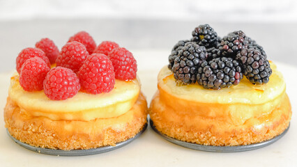 Mini cheesecakes close-up. Topping cheesecakes with orange marmalade, fresh berries, and rosemary