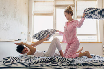 young couple having fun on bed in morning