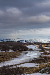 The wild rugged and natural landscape in Borgarbyggð is spectacular in winter with snow and ice and some beautiful snow covered mountains in the background, Snaefellsnes peninsula, Iceland
