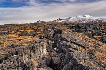 Snaefellsjokull National Park seen from Svortuloft with a cracked earth in the foreground, Snaefellsnes peninsula, Iceland