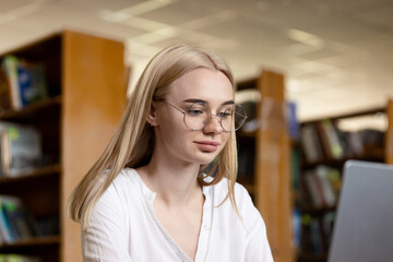 A young teenage girl in the library writes an essay or outline, taking diligent notes. This scene embodies the concepts of passing exams, studying, and education, highlighting her dedication to academ