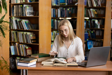 A young teenage girl in the library writes an essay or outline, taking diligent notes. This scene embodies the concepts of passing exams, studying, and education, highlighting her dedication to academ