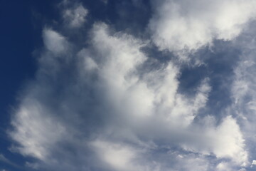 sunshine refracted shaped clouds over bright blue skies during the day