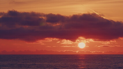 Color Of Sunlight In Sky Reflecting In Sea Water. Orange And Red Tones Reflects In Ocean.