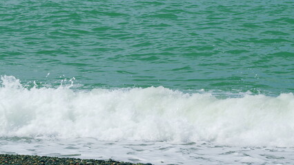 Water Breaking On Sand Forming White Foam. Ocean Waves Crashing And Foaming. Slow motion.