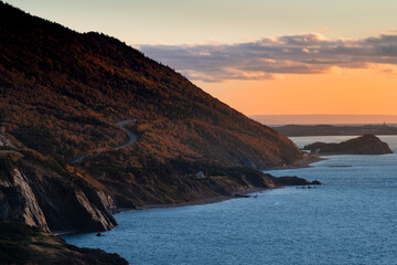 Scenic view of the coastline with the sea and mountains at the Cape Breton Highlands National Park, in Nova Scotia, Canada, at sunset.