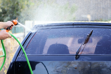 water from a hose from a spray bottle washes the car. Car washes use high pressure water sprays,...