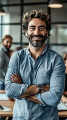 Obraz premium Smiling businessman with arms crossed, exuding confidence in a modern office setting.