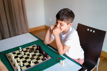 A boy is playing chess with a friend
