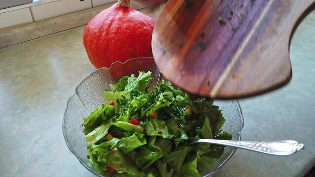 Tossing a salad in a glass bowl