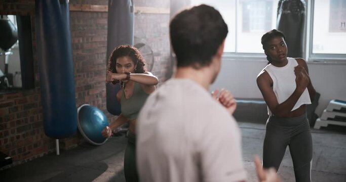 Gym, boxing and personal trainer with women for training, exercise and learning to punch. Sports center, female clients and male coach for supervision, teaching and motivation for beginner boxers