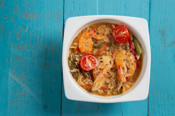 shrimp and rice vegetables pad thai sauce on a blue table. copy space.
