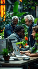 A diverse team collaborates in a modern, green office space filled with plants and multiple computer screens, suggesting creativity and productivity.