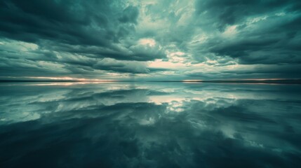 Obraz premium A cinematic view of a tranquil lake reflecting a dramatic cloudy sky, creating a symmetrical and serene scene.