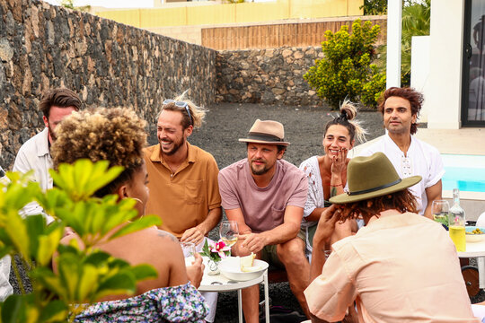 Friends enjoying a casual poolside BBQ and conversation