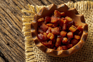 Porcelain pot with delicious pieces of fried bacon