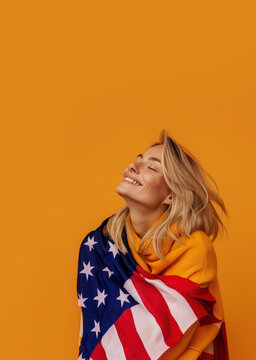 Joyful woman wrapped in American flag against orange background. Generative AI image