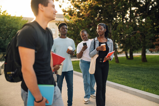 Diverse group of students walking at university campus after lectures.