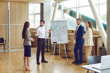 Professional business mentor gives training master class to team of male and female corporate...