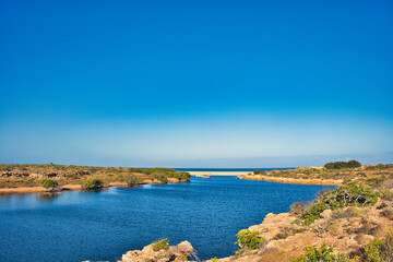 The mouth of Yardie Creek in Cape Range National Park, Western Australia. Rocks with stunted...