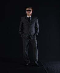 OLD BEARDED MAN businessman IN A SUIT on a black background