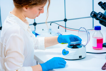 young female scientist working with a centrifuge and PCR tubes