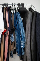 A close-up shot of clothing hanging on a metal rack, showcasing various styles and colors. 