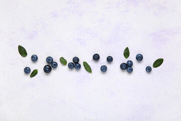 Fresh blueberries and leaves on white background