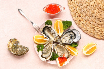 Plate of tasty oysters with lemon and red caviar on beige background