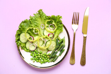 Plate of tasty vegetable salad on lilac background