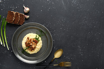 Plate of tasty banosh with bread on black background