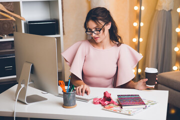 woman in pink luxury dress, summer trend, fashion designer working at office on computer