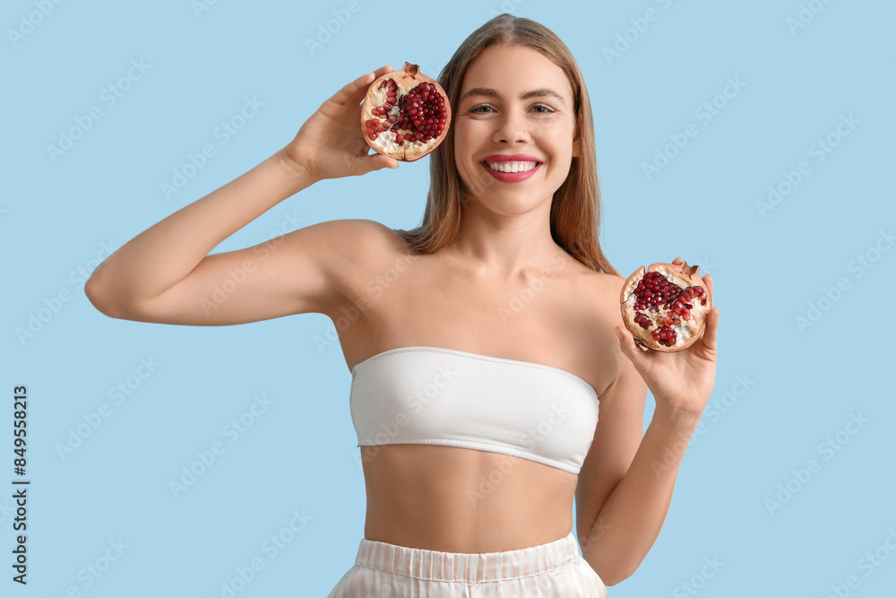 Poster Young woman with pomegranate on blue background