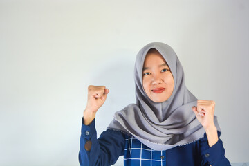 Portrait of a young Asian woman wearing a hijab with a gesture of resistance