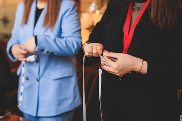 Process of checking in on a conference congress forum event, registration desk table, visitors and attendees receiving a name badge and entrance wristband bracelet and register electronic ticket
