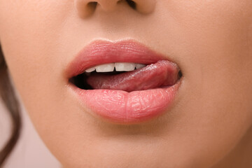 Young woman showing tongue, closeup