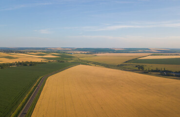 Rural aerial landscape with multicolor agriculture fields. Farm landscape, agricultural fields, beautiful countryside, country road.