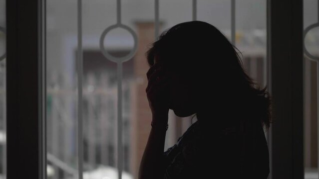 Woman's silhouette in despair with gloomy backdrop