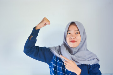 Portrait of a young Asian woman wearing a hijab with a gesture of resistance