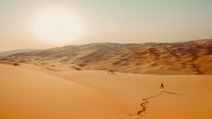 Woman in the sunset in the desert of Abu Dhabi in Emirates leaving  footprints in the sand