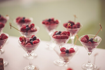 Glasses of raspberries, strawberries, blackberries on the ice bar. Gala dinner at the restaurant. served festive table with fruit. berry fruits in a glass served on catering. 